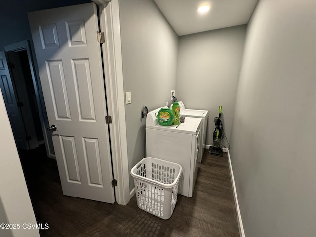 washroom with laundry area, dark wood-type flooring, washer and clothes dryer, and baseboards