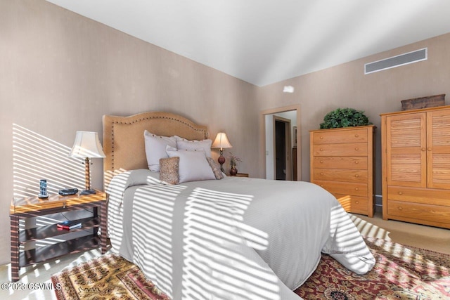 bedroom with lofted ceiling, carpet floors, and visible vents