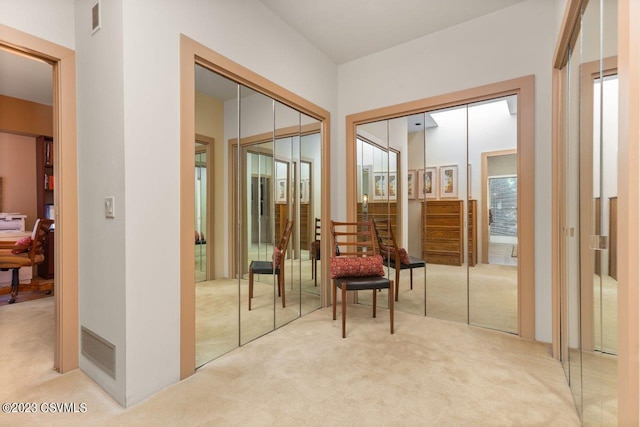 living area with a healthy amount of sunlight, carpet flooring, and visible vents