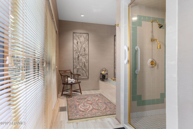 bathroom featuring a shower stall and a bath