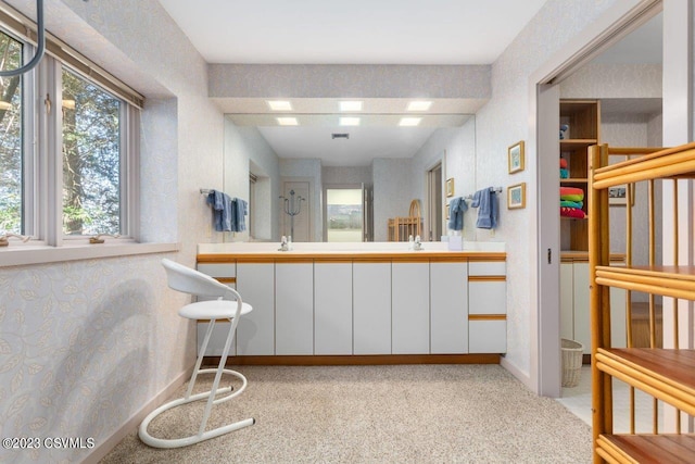 interior space featuring wallpapered walls, baseboards, and white cabinets