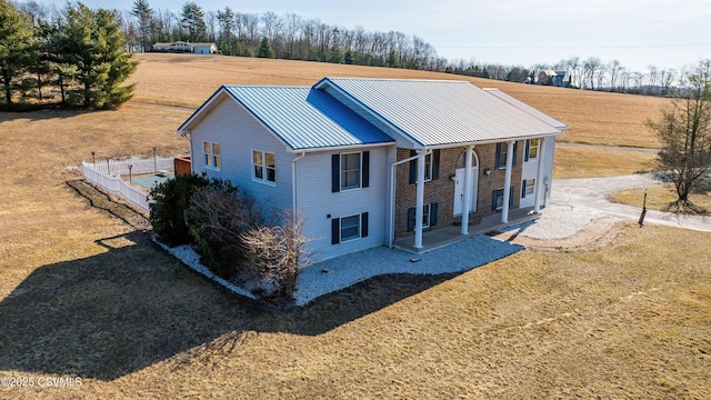 exterior space with a porch, metal roof, a front lawn, and fence