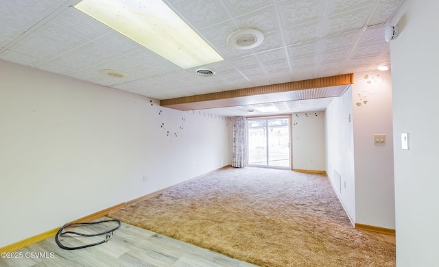 unfurnished room with visible vents, an ornate ceiling, baseboards, and carpet floors