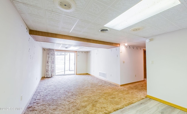 carpeted empty room featuring baseboards and visible vents