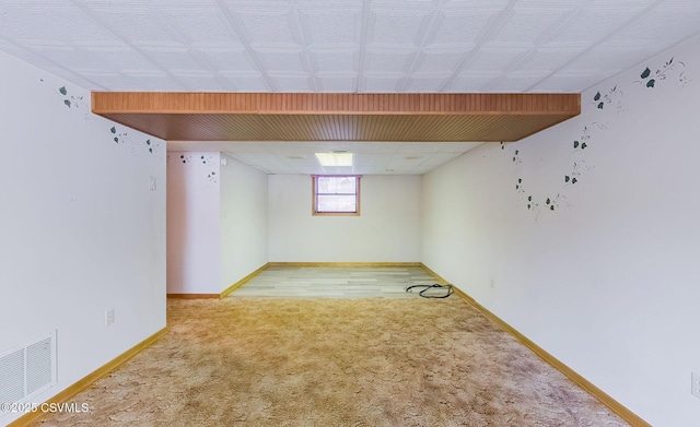 basement with visible vents, baseboards, and carpet