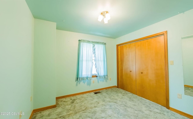 unfurnished bedroom featuring visible vents, carpet flooring, and baseboards