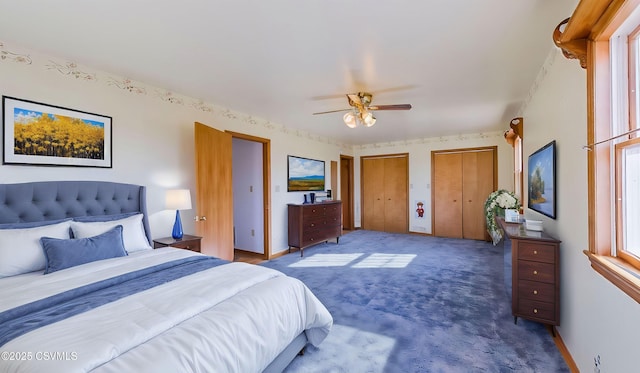 carpeted bedroom featuring multiple windows, multiple closets, baseboards, and a ceiling fan