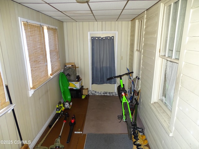 interior space with wood walls and a drop ceiling