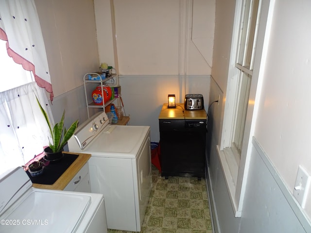 clothes washing area with laundry area, washing machine and dryer, and light floors