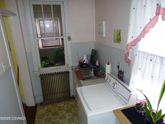 laundry area with laundry area, washer / dryer, radiator, tile patterned floors, and a sink