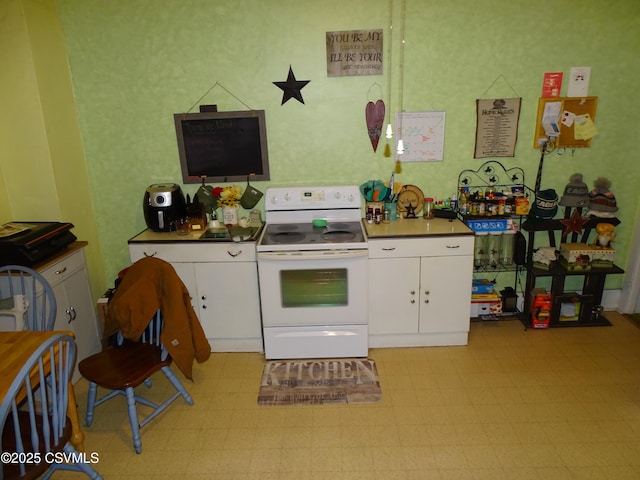 kitchen with white cabinetry, light floors, and white electric range oven