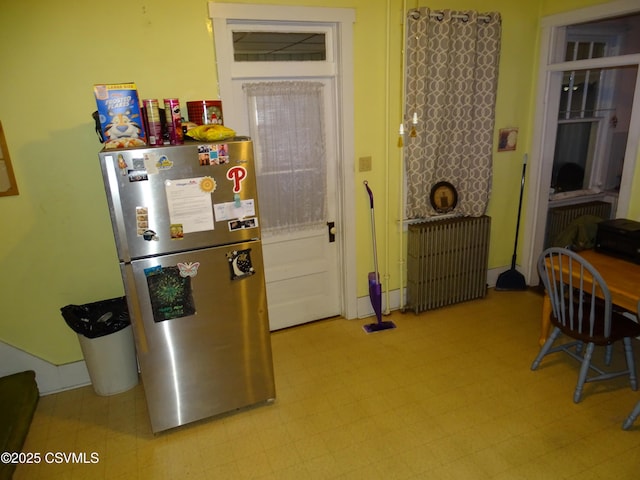 interior space with radiator, freestanding refrigerator, and tile patterned floors