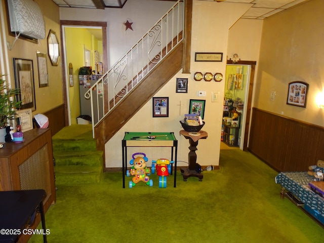 game room with wainscoting, wood walls, and carpet flooring