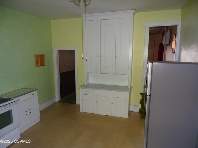 349 W 2nd St, Mount Carmel, PA 17851 - kitchen featuring light floors, baseboards, freestanding refrigerator, and white cabinetry