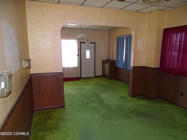 349 W 2nd St, Mount Carmel, PA 17851 - unfurnished room with an inviting chandelier, wainscoting, carpet floors, arched walkways, and wood walls