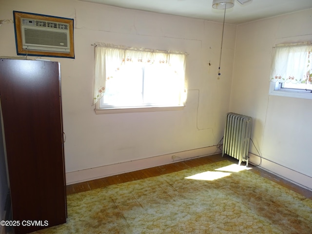 349 W 2nd St, Mount Carmel, PA 17851 - unfurnished room with baseboards, wood finished floors, radiator, and a wall mounted air conditioner