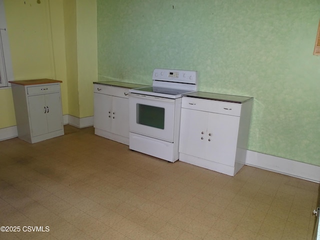 349 W 2nd St, Mount Carmel, PA 17851 - kitchen featuring white range with electric cooktop, baseboards, white cabinetry, and light floors