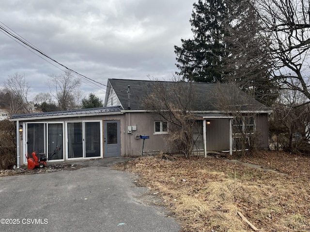 back of property featuring metal roof and a sunroom