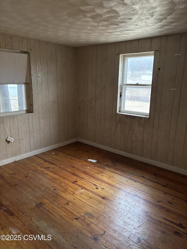 unfurnished room featuring wood-type flooring and baseboards