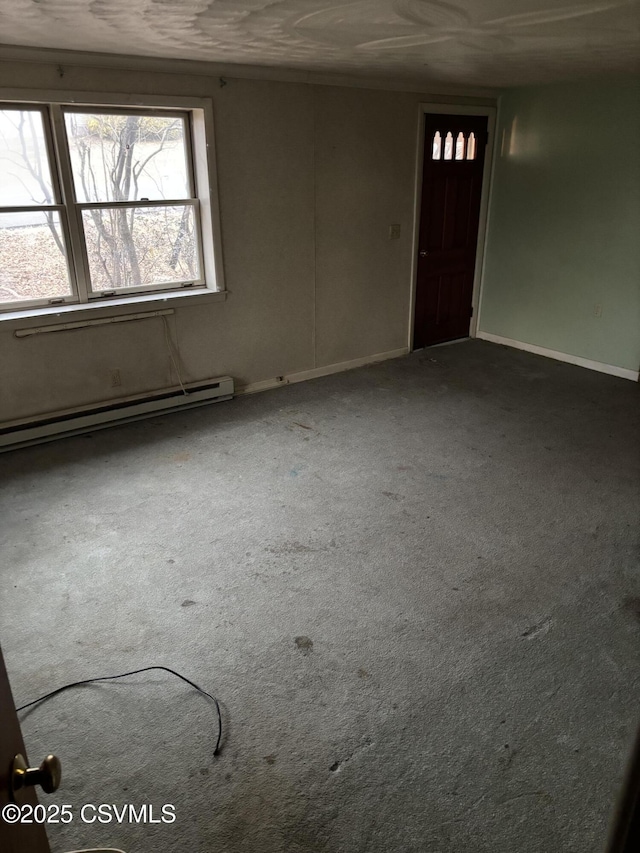 carpeted spare room featuring baseboards and baseboard heating