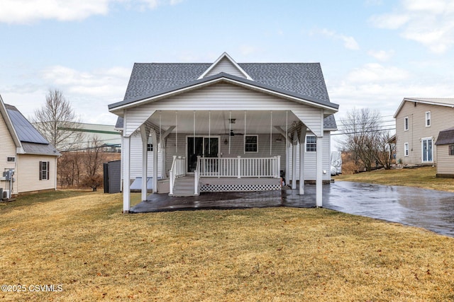 bungalow-style home with a porch, a front yard, a ceiling fan, and a shingled roof