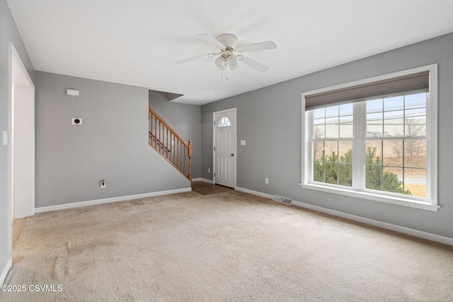 interior space featuring carpet, visible vents, baseboards, and stairs