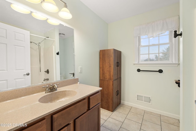 full bathroom featuring vanity, baseboards, visible vents, tile patterned floors, and walk in shower