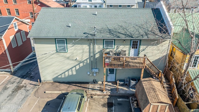 back of house featuring central air condition unit and a shingled roof