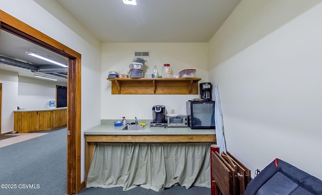 office area featuring a toaster, visible vents, carpet flooring, and a sink