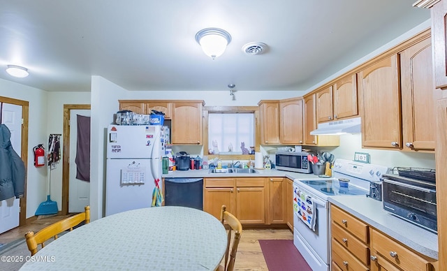 kitchen featuring visible vents, under cabinet range hood, a sink, white appliances, and light countertops