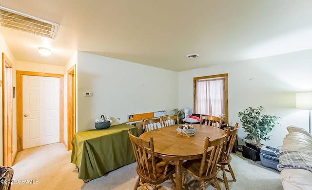 dining area with visible vents and light carpet