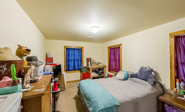 bedroom with visible vents and light carpet