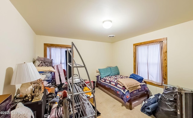 carpeted bedroom featuring visible vents