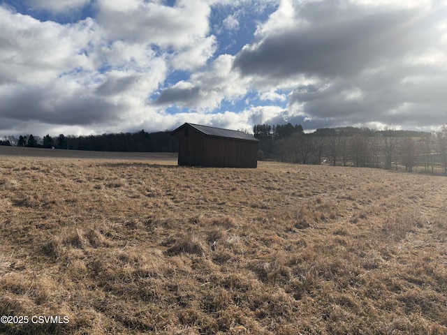 view of yard with an outbuilding and a rural view