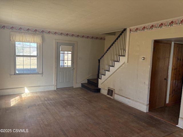 foyer entrance featuring hardwood / wood-style floors, stairway, visible vents, and baseboards