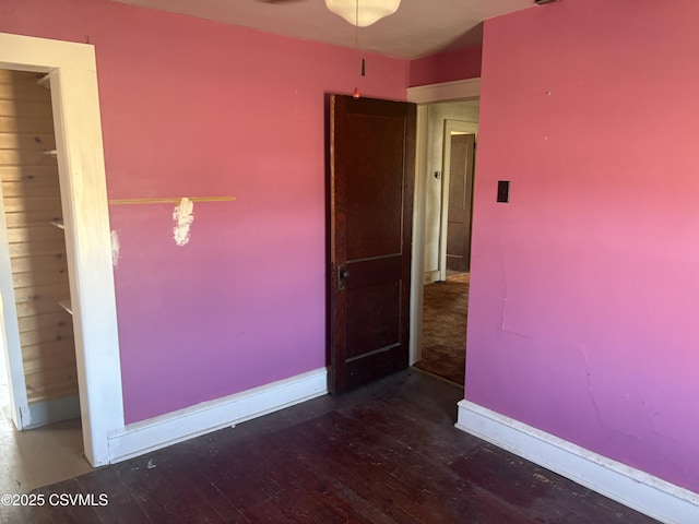 empty room featuring baseboards and wood-type flooring