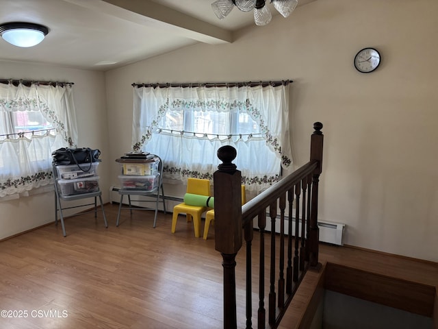 sitting room featuring an upstairs landing, vaulted ceiling with beams, and wood finished floors