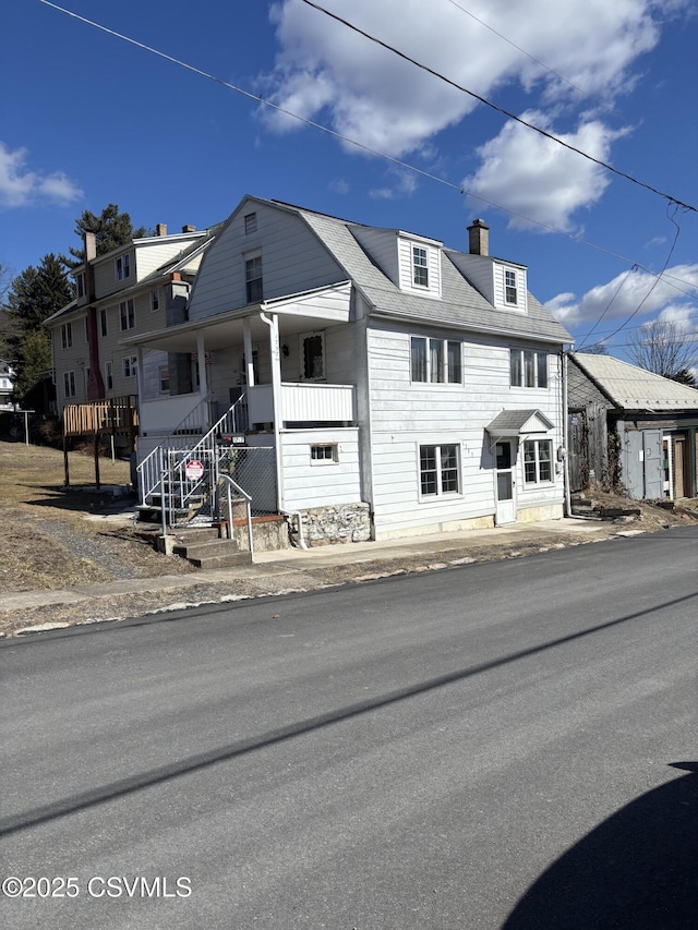 view of property with a porch and a chimney