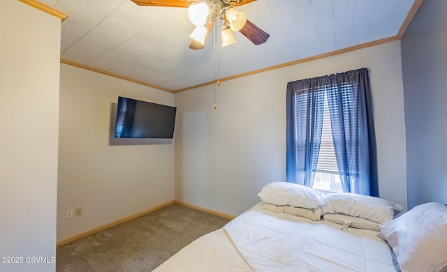 carpeted bedroom with ceiling fan, baseboards, and ornamental molding