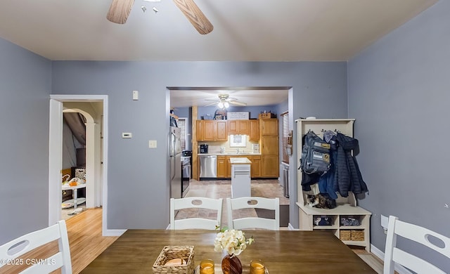 dining room with a ceiling fan, light wood-style floors, and baseboards