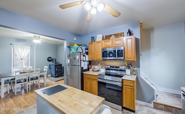 kitchen with appliances with stainless steel finishes, baseboards, and ceiling fan