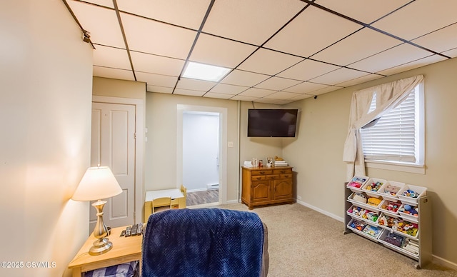 interior space featuring a drop ceiling, baseboards, and carpet