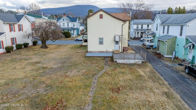 exterior space featuring a mountain view, a yard, and a residential view