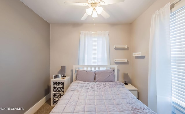 bedroom with a ceiling fan, baseboards, and carpet floors