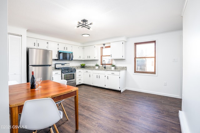 kitchen featuring a sink, stainless steel appliances, dark wood-style floors, and white cabinetry