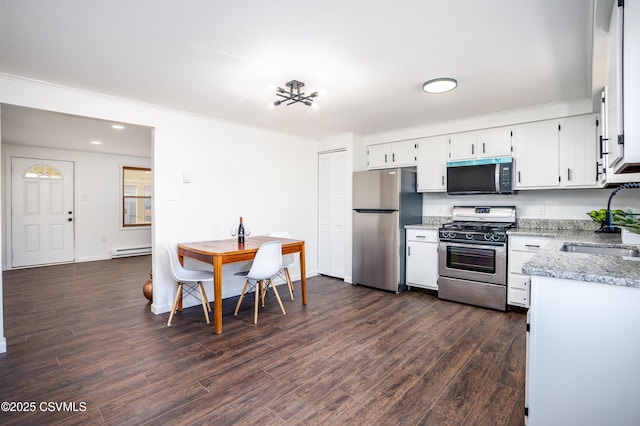 kitchen featuring a sink, baseboard heating, stainless steel appliances, white cabinetry, and dark wood-style flooring