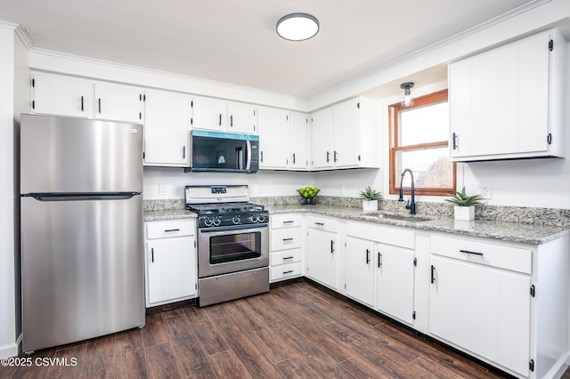 kitchen featuring white cabinets, appliances with stainless steel finishes, dark wood-type flooring, and a sink