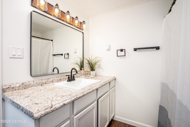 full bath with wood finished floors, baseboards, ornamental molding, and vanity