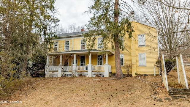 view of front facade with a porch and a chimney