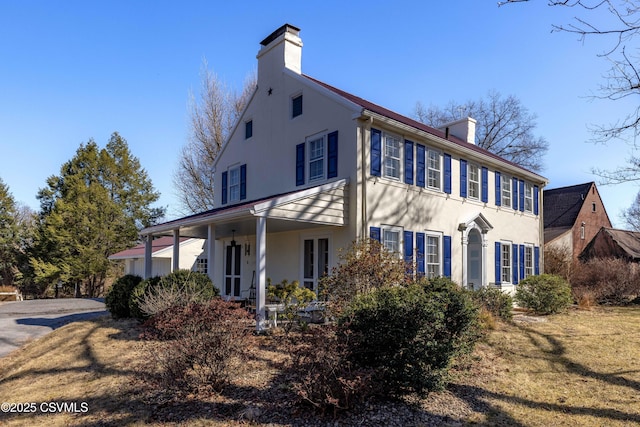 view of front of property featuring stucco siding and a chimney